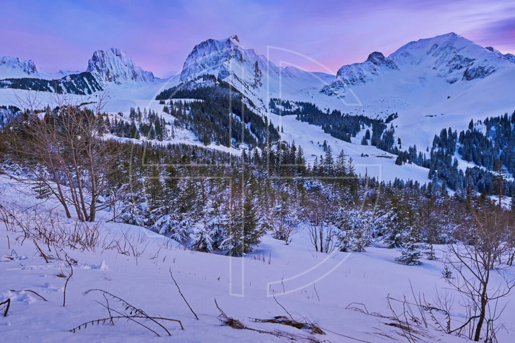 The mountains of the Gantrisch nature park in winter at dusk.