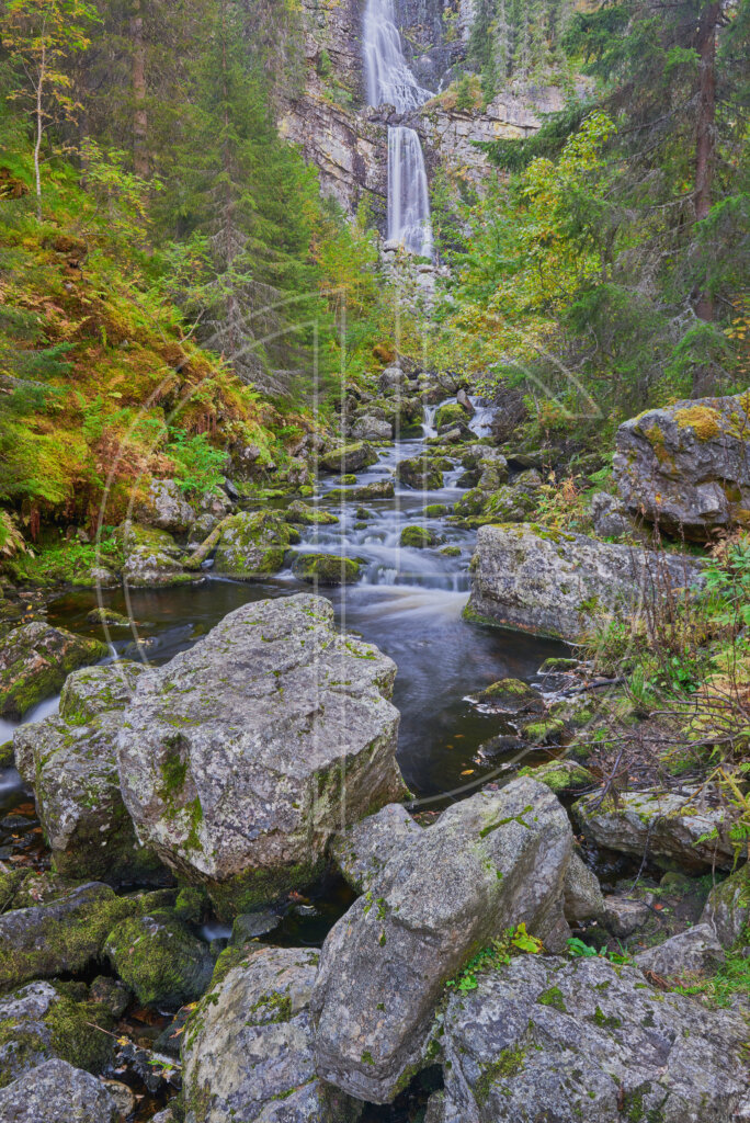 Rocks and a waterfall in the background.