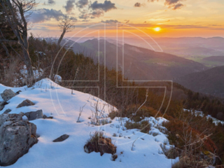 A golden sunset in a hilly landscape.