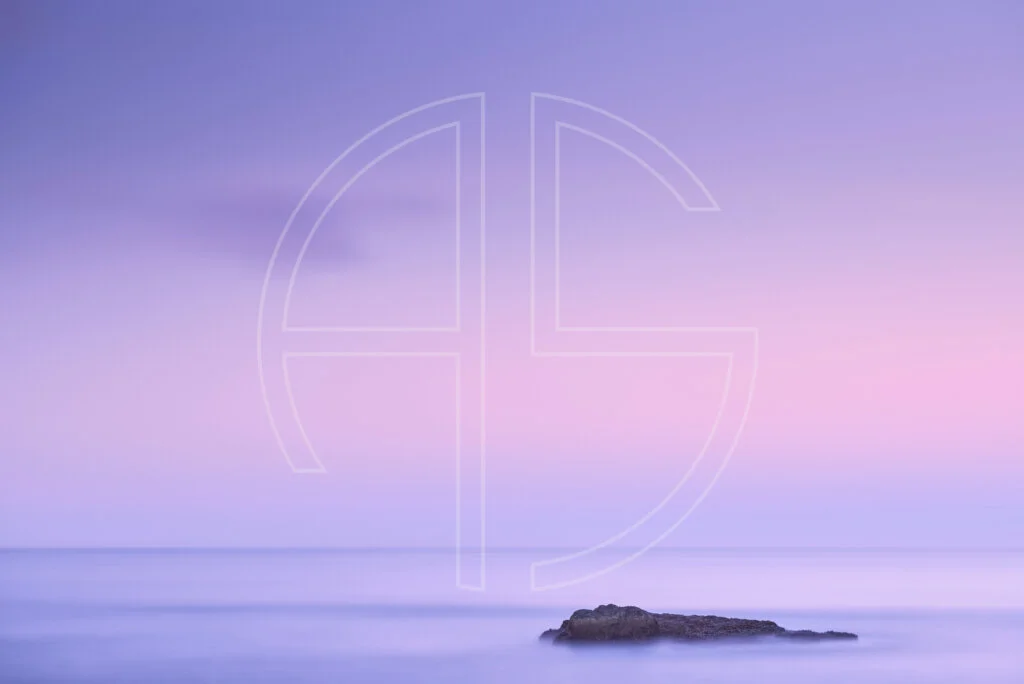 Pink dusk at the sea, one stone resting in the water.