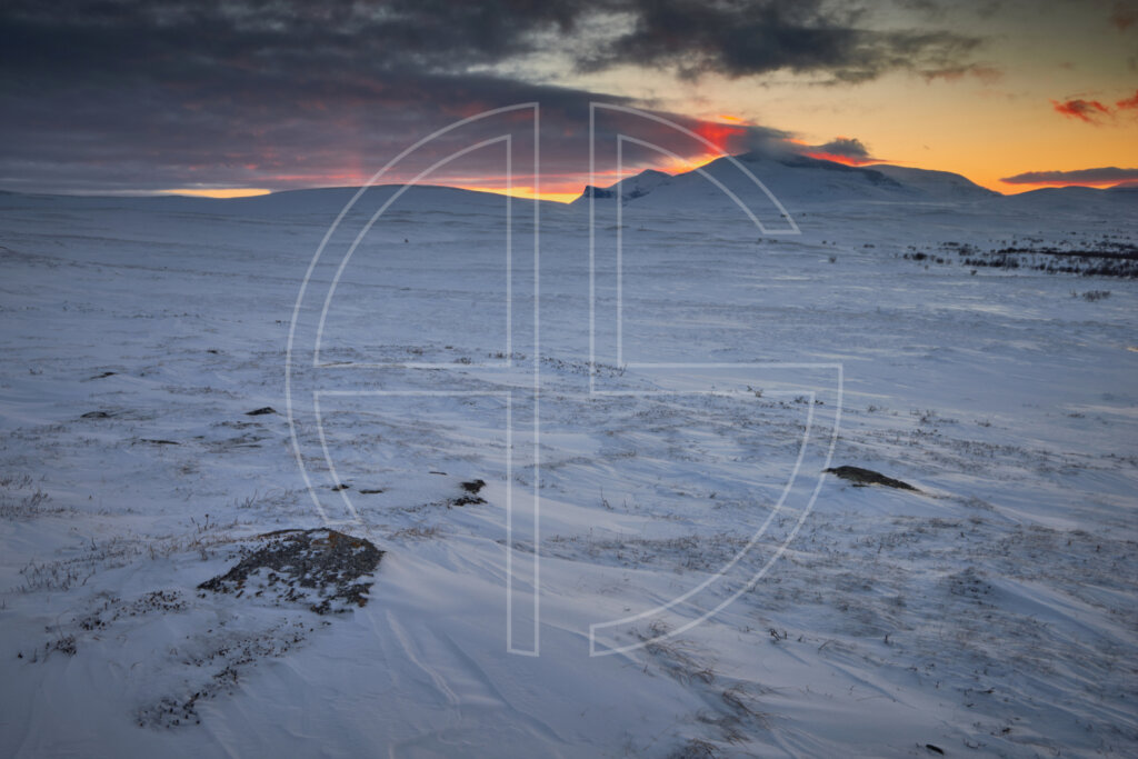 Sunset in a winter landscape. The sky broods black, orange and red.
