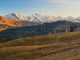 The mountains of Eiger, M&ouml;nch, and Jungfrau in soft evening light. An alpine hut graces the foreground.
