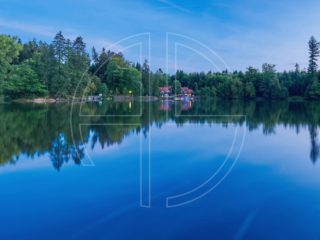 A lake at the blue hour. Looming in the distance stands a restaurant.