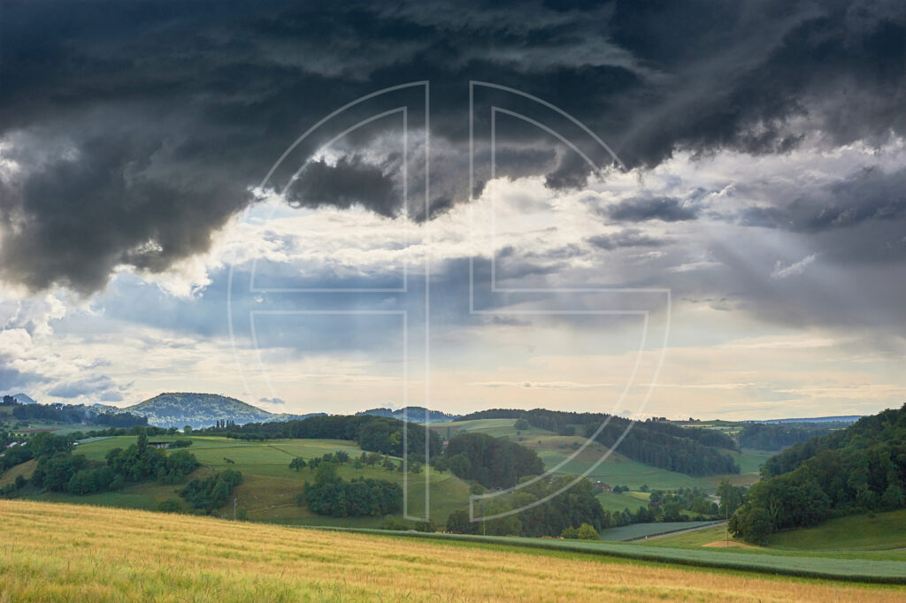 Gloomy, dramatic sky over a hilly landscape.
