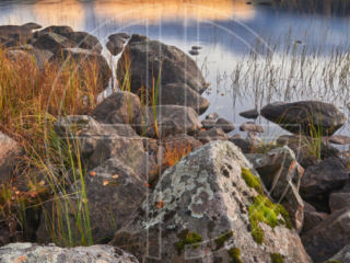 One Rain Cloud Big stones in the foreground and a lake in the background on an overcast day.