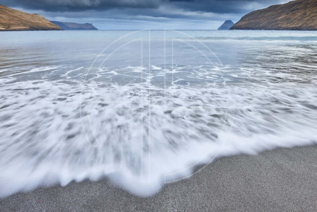 A beach with grey sand.