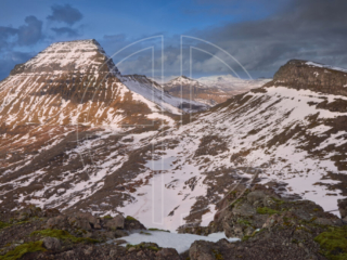 Snow-covered mountains in soft light.