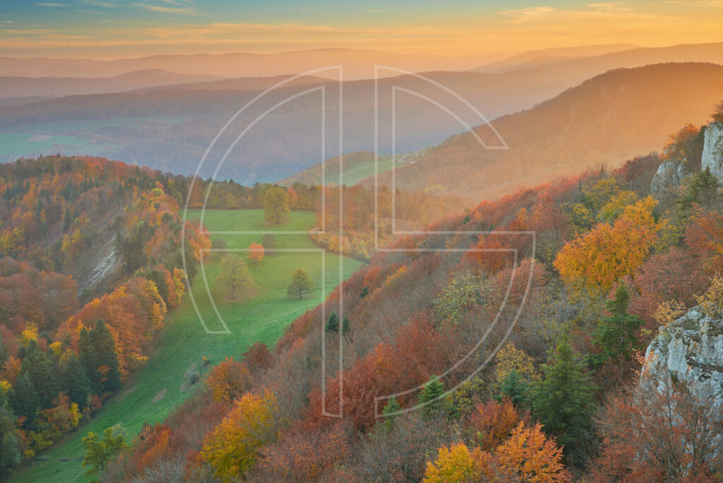 Hilly landscape in autumn colours at sunset.