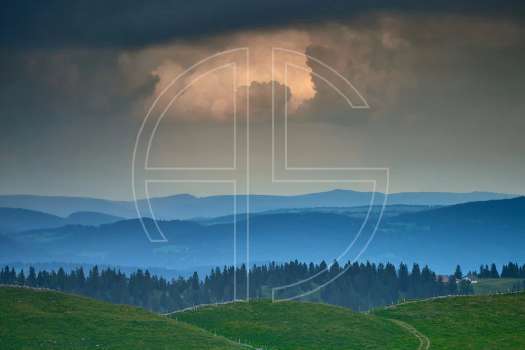 Three hills and an overcast sky.