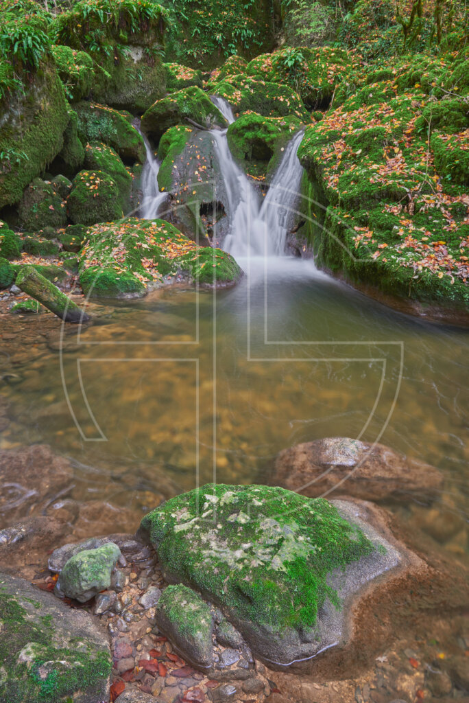 Mossy stones and a small waterfall.