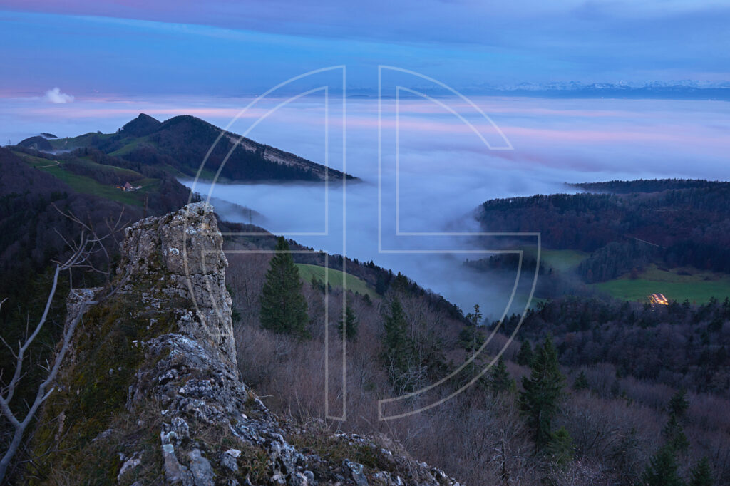 The vantage point of Belchenflue at night. A layer of fog sits in the valley below.