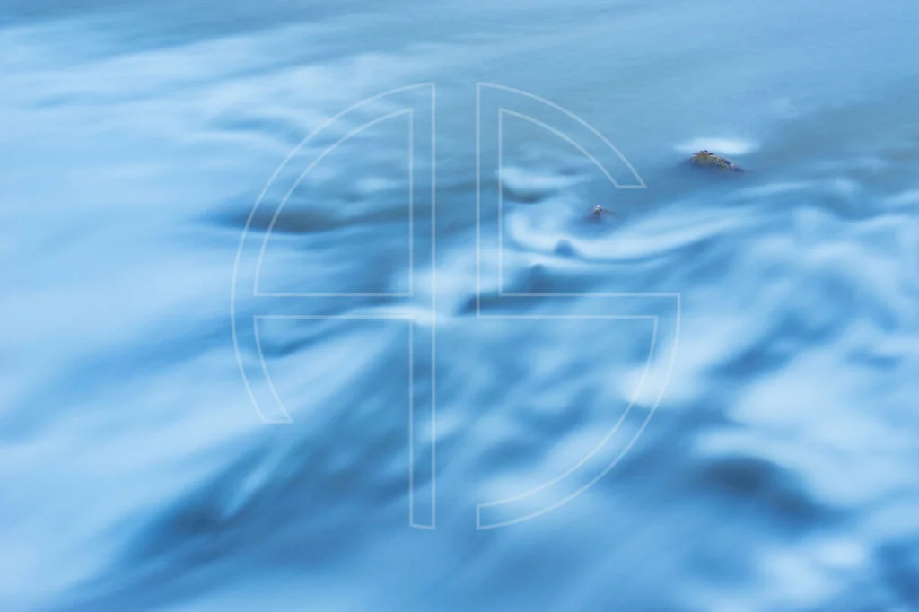 Silky smooth flowing water. Two stones peek out of the water.