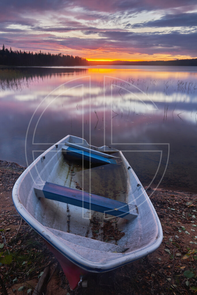 Sunset at a lake. A boat sits in the foreground.