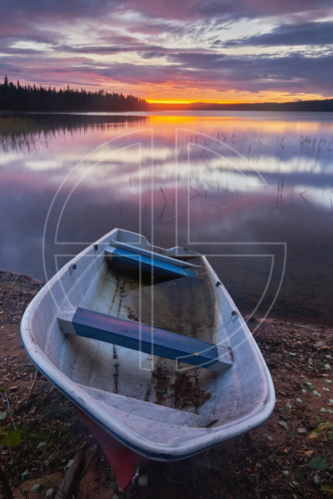 Sunset at a lake. A boat sits in the foreground.